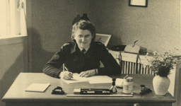 854821 Portret van Marie-Louise Jentjens (1919-2007) in uniform van het Commissariaat Noodvoorziening (C.N.V.), achter ...